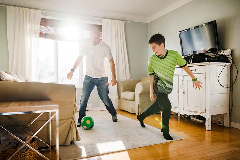 dad son play indoor soccer at home