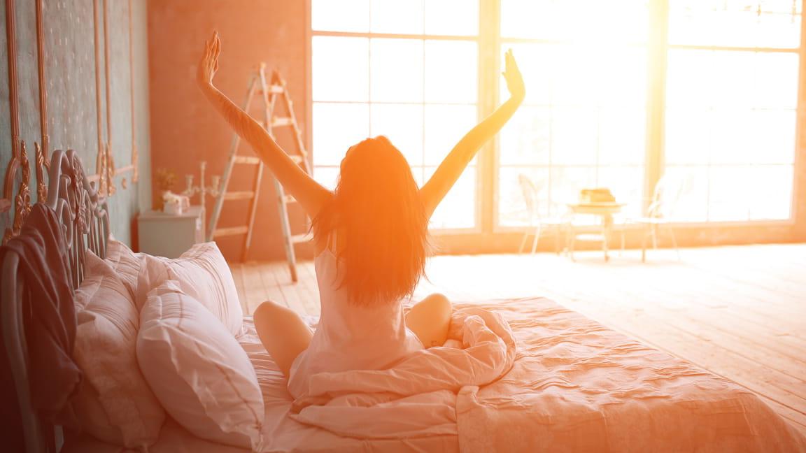 女人在黎明起床前伸展身体